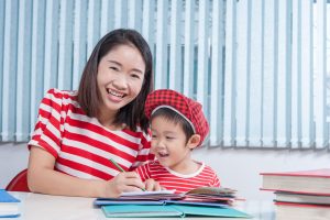 Phonics tutor teaching and helping child to smile