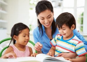Phonics tutor teaching two children how to read