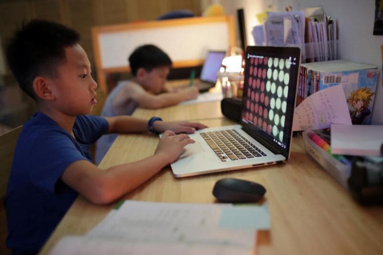 Singaporean boy does his home based learning at his computer at home