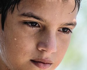 Boy sweating profusely due to warm house