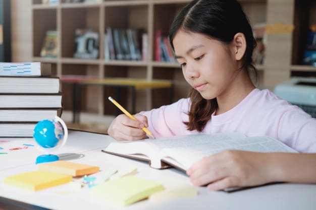 Singaporean girl revises for her PSLE examination at home with attention