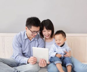 Parents in singapore use an iPad to teach their child during home based learning