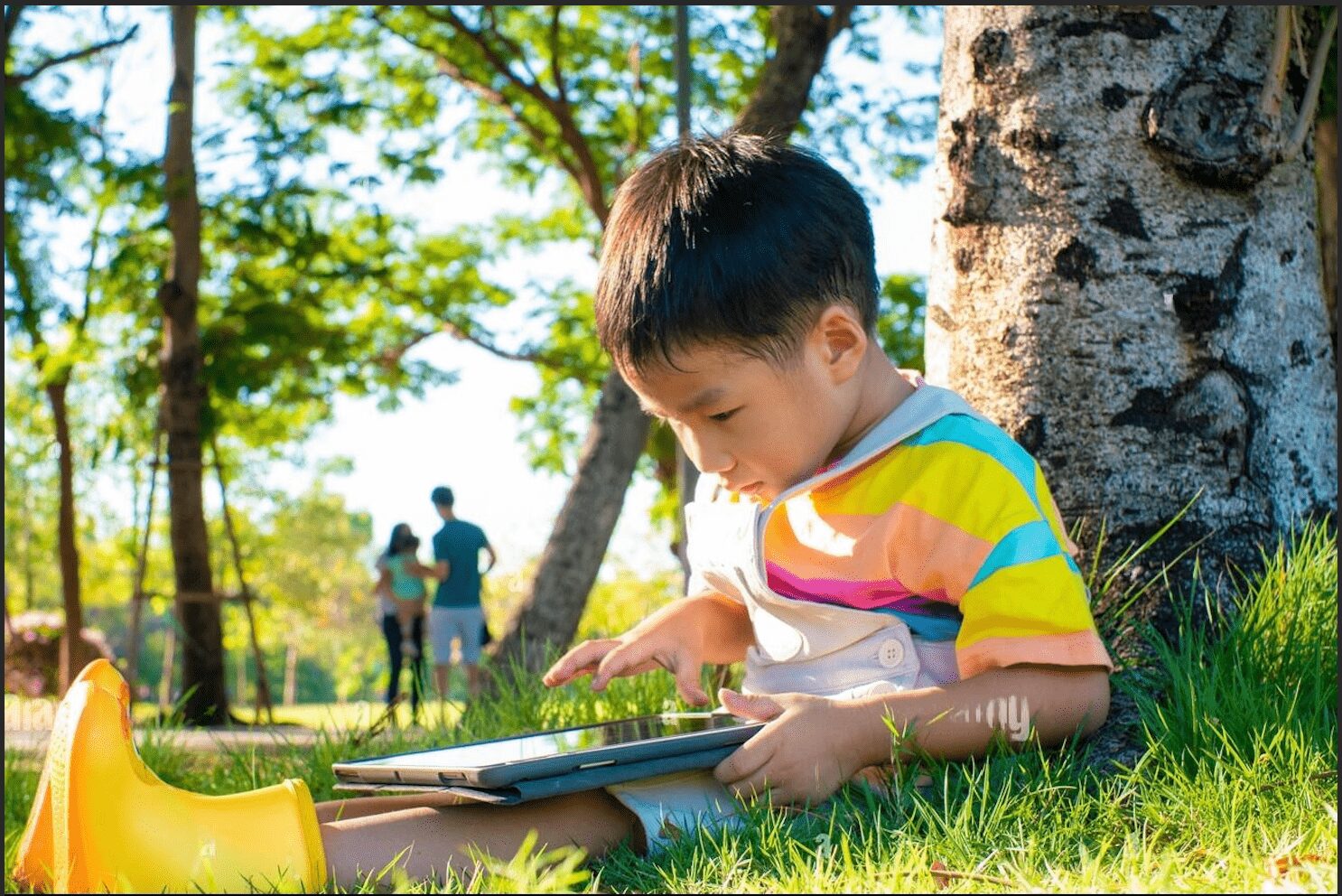 boy sitting in nature with ipad